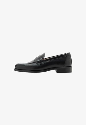 Black leather loafers with a sleek design, smooth texture, prominent stitching, and a low block heel. No visible hardware or embellishments.