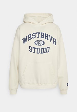 Krémová mikina s kapucí vyrobená z měkkého materiálu má přední kapsu, žebrované manžety a výrazné tmavě modré grafické logo na hrudi.