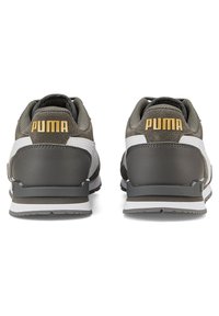 Sive tenisice od premaza s naglašenom bijelom prugom i zlatnim "PUMA" logotipom na peti. Zaobljenog oblika s teksturiranom gornjom stranom i gumenim potplatima.