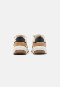 Sneaker aus cremigem Leder mit sandfarbigen Wildlederakzenten, ausgestattet mit einem schwarzen Fersen-Detail und einer strukturierten weißen Gummisohle. Logo an der Ferse.