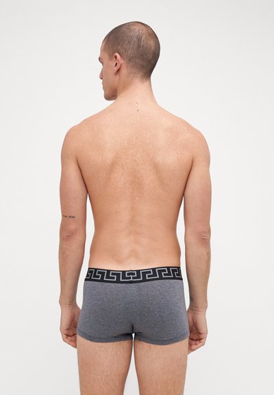 Grå bomullsboxershorts med en svart geometrisk mønsterliv, tettsittende design og glatt tekstur, sett fra bak.