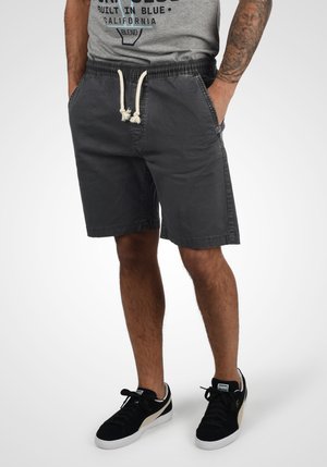 Shorts en coton gris avec une taille élastique et un cordon de serrage. Dispose de deux poches latérales et d'une coupe décontractée, se terminant juste au-dessus du genou.