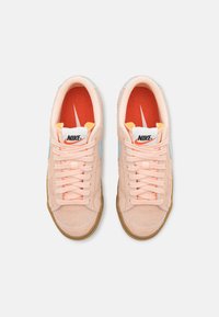 Nike sporta apavi persiku zamšā ar pasteļzilo akcentu. Funkcijas: gumijas zole, auklu aizdare un oranžs iekšzole ar logo.
