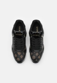 Svarta sneakers med texturerat läderövre, guldbranding och mönstrade detaljer i bruna nyanser. Har en klassisk snörningsdesign.