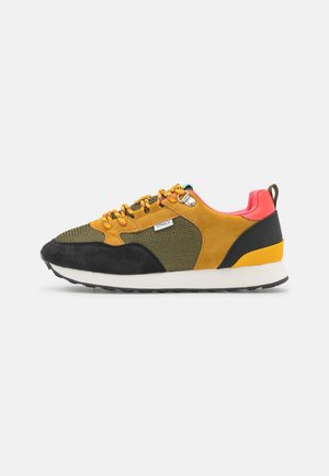 Wielobarwny sneaker z oliwkową siateczką, żółtymi i czarnymi panelami ze skóry zamszowej, pomarańczowymi sznurowadłami, koralowo-różowym kołnierzem, białą podeszwą i pętelką na pięcie.