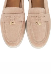 Pink suede loafers with a flat, white rubber sole. Accented with a decorative bow and gold hardware on the front. Smooth texture.