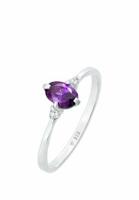 Inel din argint sterling cu o piatră centrală ovală de ametist, flancată de două mici pietre clare. Bandă netedă, polisată; design elegant.