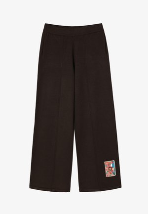 Pantaloni de trening largi, de culoare maro, cu un tiv ribbed, buzunare laterale și o aplicație colorată care prezintă un design abstract pe coapsa stângă.