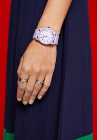 Hellblaues Armband mit rundem Zifferblatt und strukturiertem Silikonarmband. Das Zifferblatt hat einen weißen Hintergrund und dünne schwarze Stundenmarkierungen.