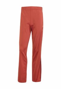 Red athletic pants made of smooth, breathable fabric. Features an elastic waistband and side zippers along the legs for adjustable fit.