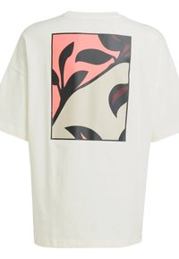 Cremefarvet oversized t-shirt med et grafisk print af sorte blade på en fersken- og hvid baggrund. Kortærmede og rund hals.