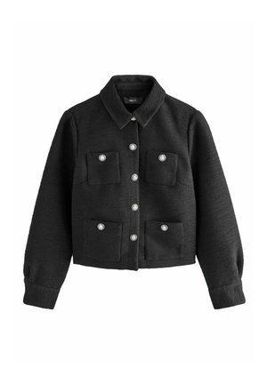 Veste cropped noire en tissu texturé avec un col, fermeture à boutons argentés et deux poches plaquées à l'avant.