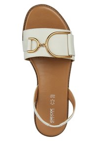 Sandal in pelle bianca con una fascia larga, accenti in metallo dorato e una suola marrone. Presenta una fibbia rotonda e un design minimalista.