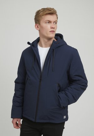Navy blue insulated jacket featuring a hood, zip closure, and side pockets. Smooth texture with adjustable drawstrings and contrast stitching details.
