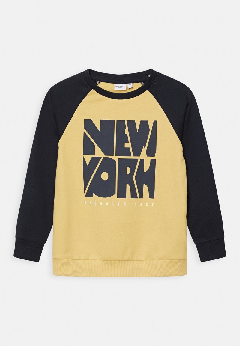 Sweat-shirt jaune à col rond avec manches raglan noires. Présente un graphisme audacieux "NEW YORK" et le texte "BROOKLYN RACE" en blanc. Matière en mélange de coton.
