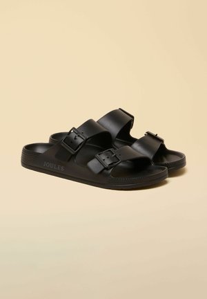 Schwarze Slip-On-Sandalen mit zwei breiten, verstellbaren Schnallenriemen, strukturiertem Sohlenprofil und "Joules"-Markenlogo an der Seite.