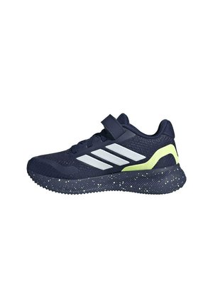 Zapatilla deportiva azul oscuro con rayas blancas, acento amarillo en el talón, suela moteada, cordones y cierre de velcro sobre fondo blanco.