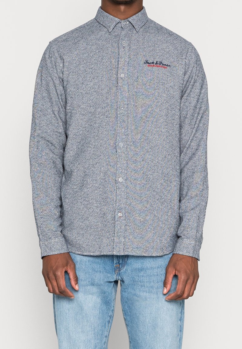 Pánská košile s dlouhým rukávem a knoflíky, v modrobílém tečkovaném vzoru, vyrobená z měkké látky, s límečkem na knoflíky a vyšitým logem.