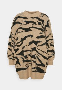 Suéter beige de gran tamaño con rayas abstractas de tigre negras, con cuello redondo, puños y dobladillo acanalados.