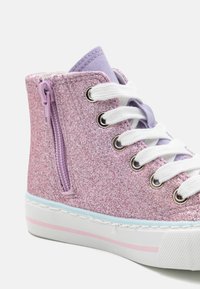 High-top sneakers with a glitter pink exterior, lilac accents, white laces, and side zipper. Features a white sole with a pink stripe.