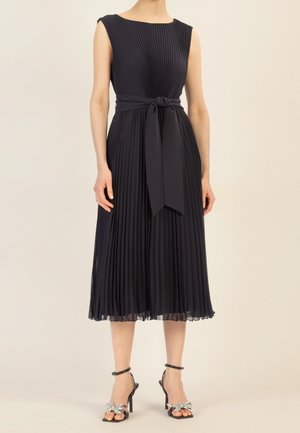 Marineblaues, plissiertes Kleid mit rundem Ausschnitt und gebundenem Taillensatin. Der Stoff ist leicht, der Rock reicht bis zum Knöchel und hat einen dezenten Glanz.