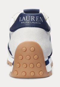 Sneaker alb cu accente albastre, având un toc din suede moale, talpă din cauciuc cu textură pentru aderență și logo-ul "LAUREN RALPH LAUREN" pe spate.