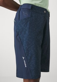 Ναυτικό μπλε σορτσάκια με λεπτό μοτίβο, που διαθέτουν πλαϊνή τσέπη, αντιθετικά αξεσουάρ και λογότυπο κοντά στο στρίφωμα. Κατασκευασμένα από ελαφρύ υλικό.