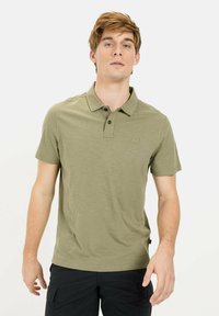 Oliven grøn polo skjorte i blødt materiale, med en tre-knaps placket og et lille logo på brystet. Korte ærmer og en afslappet pasform.