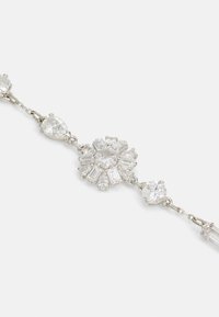 Silberarmband mit verschiedenen klaren Edelsteinen, darunter birnen- und rechteckige Schliffe, die in einem floralen Muster mit verbundenen Kettengliedern angeordnet sind.