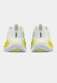 Ζευγάρι λευκών και κίτρινων αθλητικών παπουτσιών από πίσω, δείχνοντας υφασμένες σόλες και θηλιές άντλησης σε λευκό φόντο.