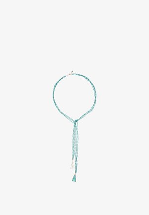 Collier de perles turquoise à plusieurs rangs, avec un détail en nœud et un pendentif pompon. Les rangs varient en longueur pour un effet cascade.
