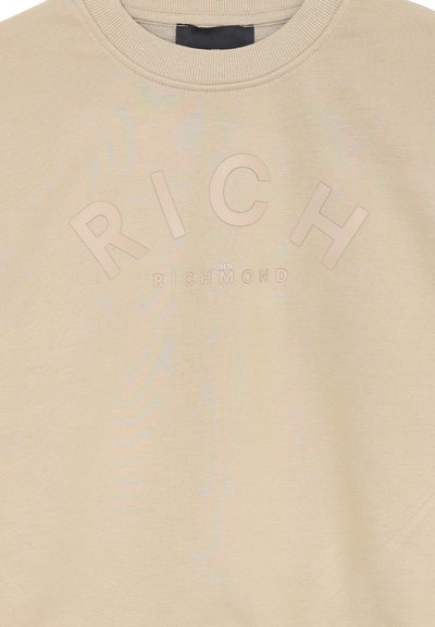 Felpa beige realizzata in tessuto liscio, caratterizzata dal testo in rilievo "RICH JOHN RICHMOND" in un colore a contrasto e un design in carattere audace.