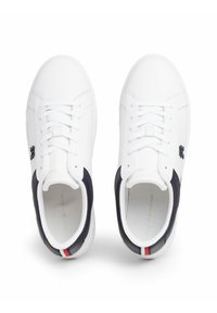 Białe sneakersy o eleganckim designie, z granatowymi akcentami, okrągłym noskiem i płaskimi sznurowadłami. Zawierają teksturowaną gumową podeszwę i złote litery.