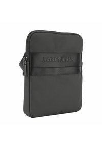 Črna oblazinjena torba čez ramo z gladko teksturo, ki ima opazen črn trak z vklesanim napisom "JOOP! JEANS" v minimalističnem oblikovanju.