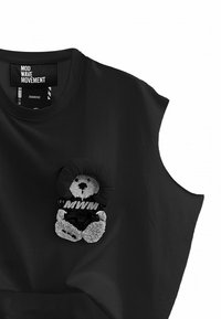 Camiseta sin mangas negra que presenta un aplique de oso de peluche con una cara redonda y tela floral, mostrando el texto "MWM" en blanco.