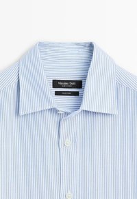 Camicia a righe blu e bianche con colletto classico, dotata di bottoni bianchi e un'etichetta che riporta "Massimo Dutti" e "Tessuto Italiano."