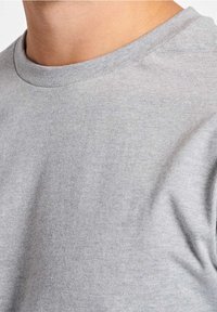 T-shirt grigio chiaro a girocollo realizzata in morbido tessuto di cotone. Presenta una texture liscia, maniche corte e un design semplice e classico.