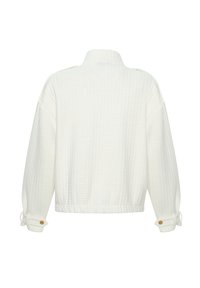 Veste matelassée blanche à manches longues, col montant, poignets boutonnés et taille élastique, vue de dos sur fond blanc.