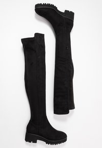 Stivali neri sopra il ginocchio in morbido suede, con suola bassa e spessa, zip laterale e design liscio e sofisticato.