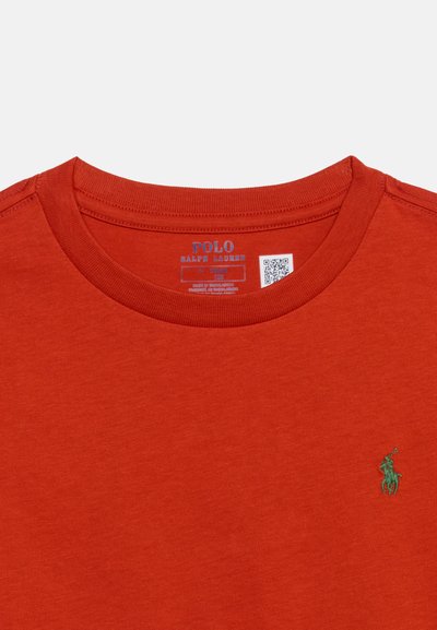 Κοντινό πλάνο πορτοκαλί μπλούζας Polo Ralph Lauren με λαιμόκοψη και πράσινο κεντητό λογότυπο αλόγου και αναβάτη στο στήθος.