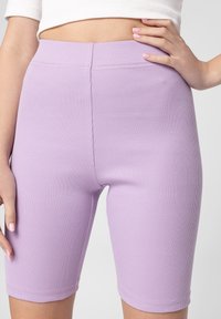 Lila ribbade cykelshorts med hög midja, slät yta och sydda sömmar, som ger en åtsittande silhuett.