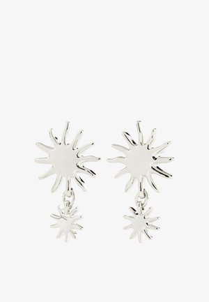 Náušnice z kovu v striebornej farbe so slnečnými lúčmi, každá s väčším náušnicovým cvokom so slnečnými lúčmi a menším kúskom so slnečnými lúčmi visiace pod ním.