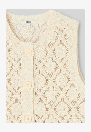 Veste en tricot crochet couleur crème avec motifs floraux et losanges, col rond et trois boutons crème sur le devant.