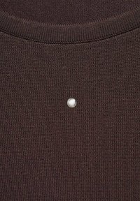 Tessuto a maglia marrone con una fine trama a coste, caratterizzato da un singolo accento decorativo di perla bianca vicino al collo.