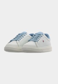 Άσπρα αθλητικά παπούτσια με λεπτομέρειες σε ανοιχτό μπλε στα κορδόνια και τη φτέρνα. Διαθέτουν ομαλή υφή, στρογγυλεμένη μύτη και διακριτικό λογότυπο στο πλάι. Λαστιχένια σόλα.