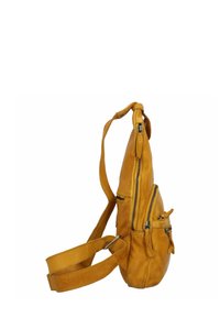 Zeven leren schoudertas in geel met meerdere ritszakken, een verstelbare schouderriem en een gestructureerde afwerking. Het zijprofiel benadrukt de vorm.