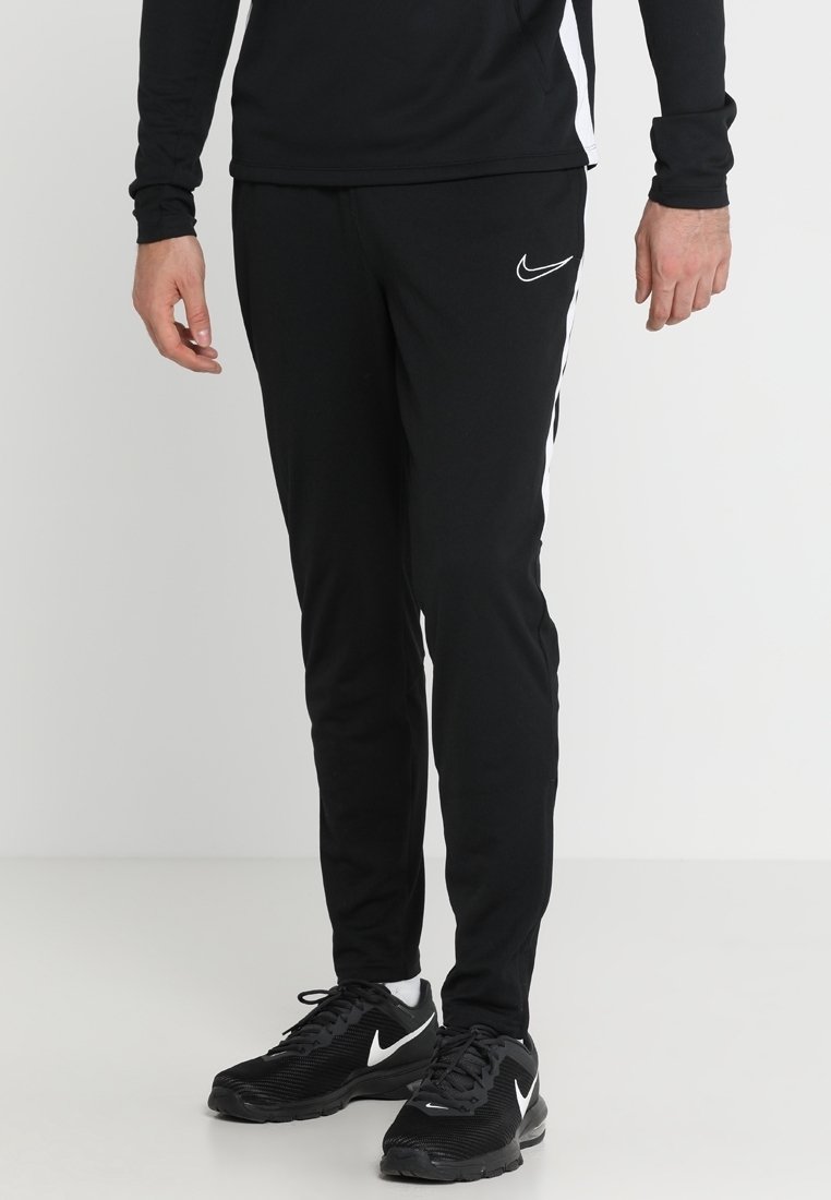 Schwarze Sporthose mit schlanker Passform, mit weißen Seitenstreifen und Nike-Logo. Aus leichtem Stoff mit einer glatten Textur gefertigt.