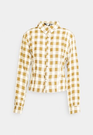 Camisa de manga longa com colarinho, em padrão xadrez amarelo e branco. Apresenta um fecho de botão à frente e um design ajustado com laterais franzidas.