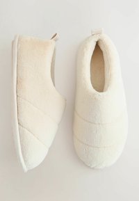 Fluffy crèmekleurige slippers met een zachte textuur, met een gesloten neusontwerp en subtiele gestikte accenten op de bovenkant.