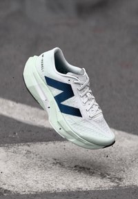 White running shoe with a textured upper, navy accents, slim profile, and a light green outsole, featuring a prominent "N" logo on the side.